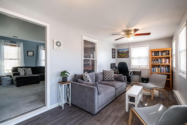 living area featuring plenty of natural light, dark wood-style floors, and ceiling fan