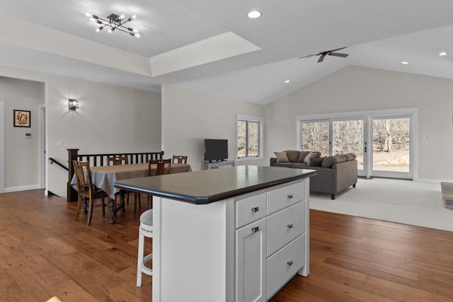 W4668 Reetz Rd, Princeton, WI 54968 - kitchen with dark countertops, a kitchen island, ceiling fan, open floor plan, and white cabinets