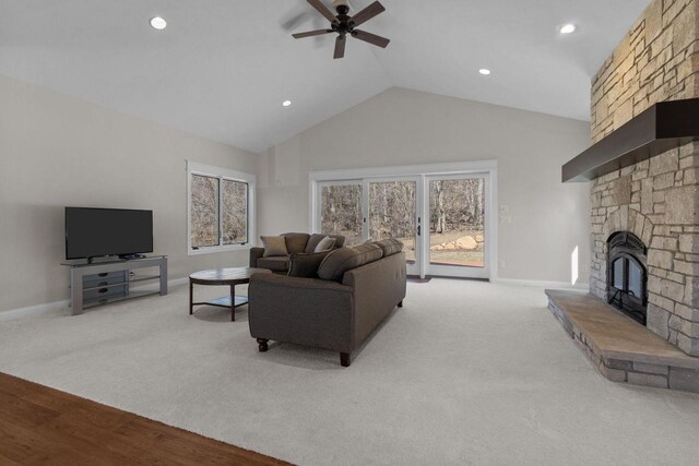 W4668 Reetz Rd, Princeton, WI 54968 - living room featuring ceiling fan, a stone fireplace, high vaulted ceiling, baseboards, and light carpet