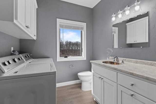 W4668 Reetz Rd, Princeton, WI 54968 - bathroom featuring independent washer and dryer, vanity, wood finished floors, toilet, and baseboards