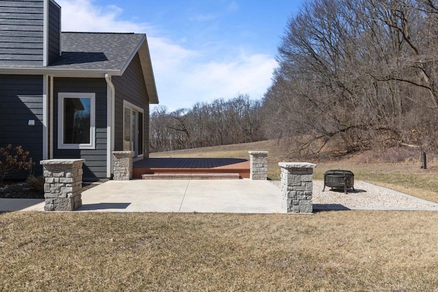W4668 Reetz Rd, Princeton, WI 54968 - view of home's exterior featuring a fire pit, a shingled roof, a patio area, and a yard