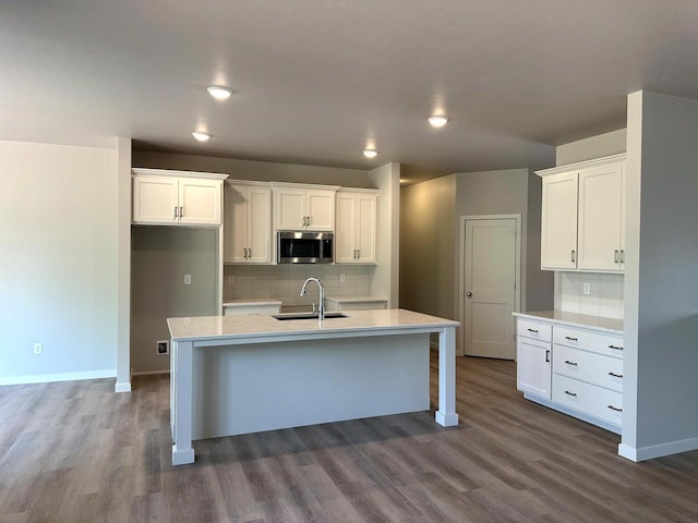 N9249 Constellation Dr, Appleton, WI 54915 - kitchen featuring stainless steel microwave, dark wood finished floors, decorative backsplash, white cabinets, and recessed lighting
