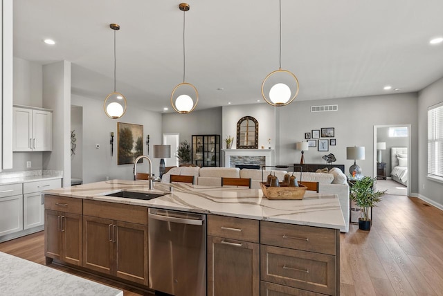 W214N4987 Casey Ct, Menomonee Falls, WI 53051 - kitchen with stainless steel dishwasher, open floor plan, white cabinetry, wood-type flooring, and recessed lighting