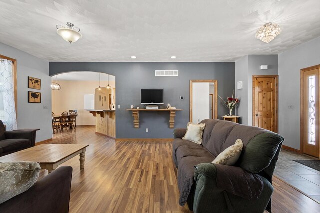 8464 County Rd S, Pulaski, WI 54162 - living room with arched walkways, visible vents, wood finished floors, and baseboards
