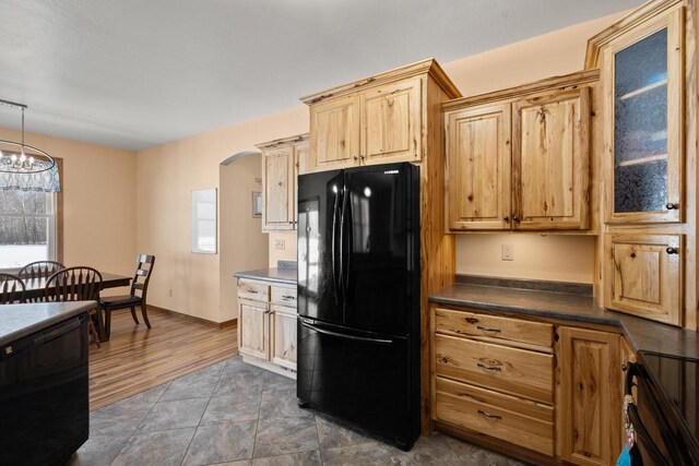 8464 County Rd S, Pulaski, WI 54162 - kitchen with baseboards, a chandelier, dark countertops, arched walkways, and black appliances