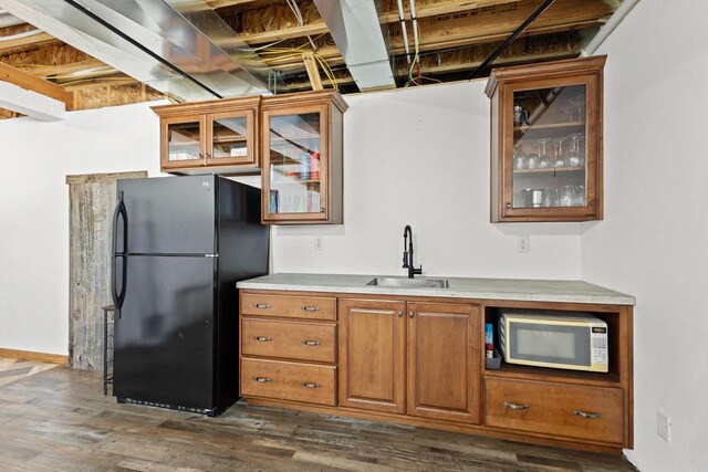 8464 County Rd S, Pulaski, WI 54162 - kitchen featuring brown cabinets, dark wood-type flooring, a sink, white microwave, and freestanding refrigerator