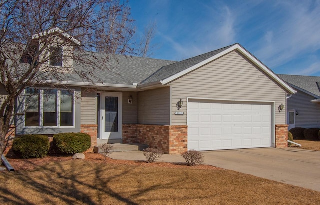 1552 Nature Trl, Hartford, WI 53027 - view of front of house featuring an attached garage, brick siding, concrete driveway, and roof with shingles