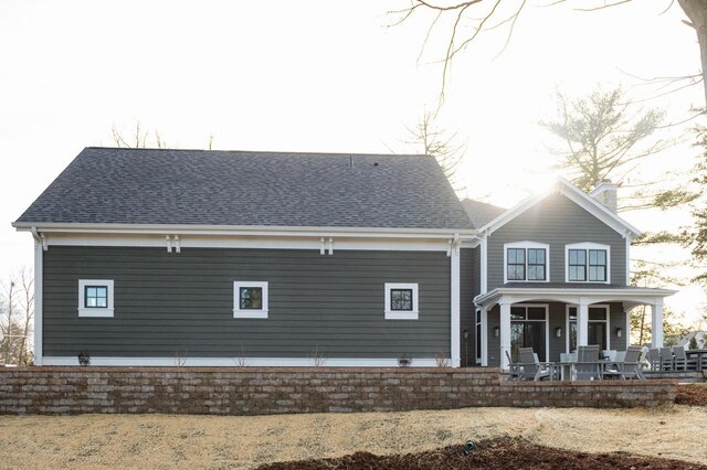 545 Wisconsin Ave, Delafield, WI 53018 - rear view of house with a porch, roof with shingles, and a chimney