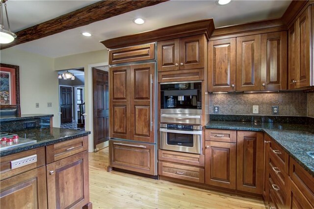 3736 Forest Knoll Dr, Eau Claire, WI 54701 - kitchen featuring backsplash, light wood-style flooring, beam ceiling, and dark stone counters