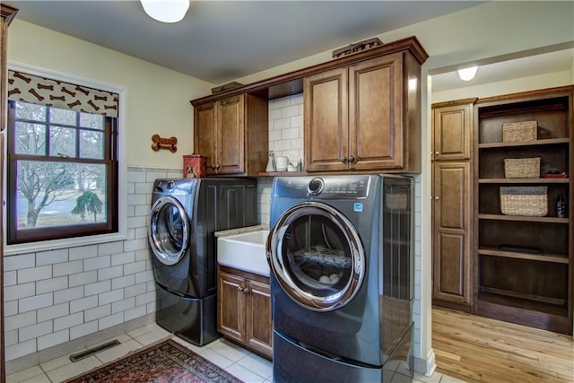 3736 Forest Knoll Dr, Eau Claire, WI 54701 - clothes washing area featuring tile walls, visible vents, wainscoting, cabinet space, and washer and clothes dryer