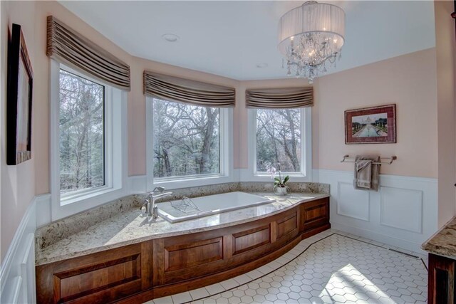 3736 Forest Knoll Dr, Eau Claire, WI 54701 - bathroom featuring a wainscoted wall, a notable chandelier, tile patterned flooring, a bath, and a decorative wall