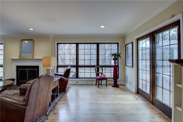3736 Forest Knoll Dr, Eau Claire, WI 54701 - living room featuring crown molding, baseboards, wood finished floors, recessed lighting, and a glass covered fireplace