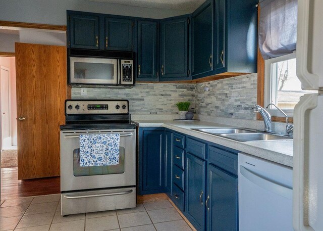 102 Highland St, Belmont, WI 53510 - kitchen featuring a sink, light tile patterned floors, appliances with stainless steel finishes, and blue cabinets
