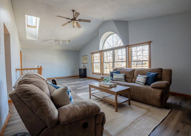 102 Highland St, Belmont, WI 53510 - living area featuring baseboards, ceiling fan, a textured ceiling, lofted ceiling with skylight, and wood finished floors