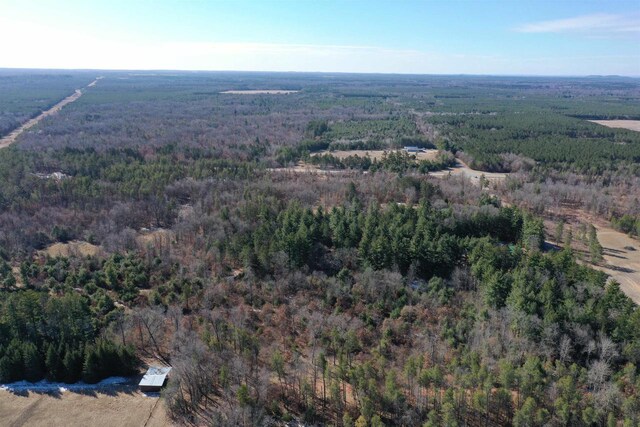 drone / aerial view with a wooded view