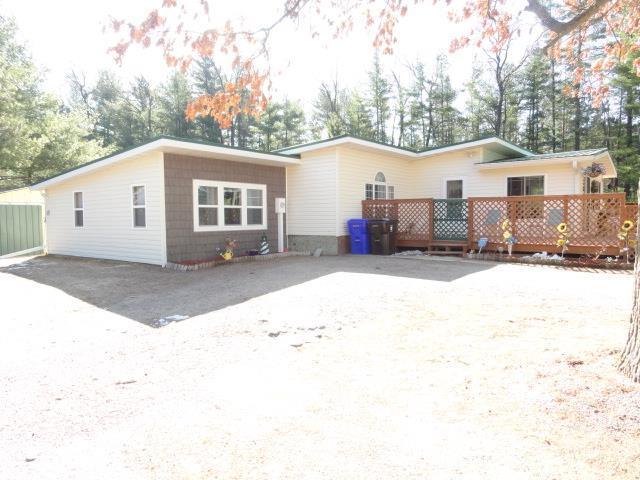 rear view of house with driveway and a wooden deck