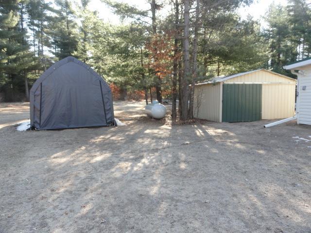 view of yard featuring a shed and an outbuilding
