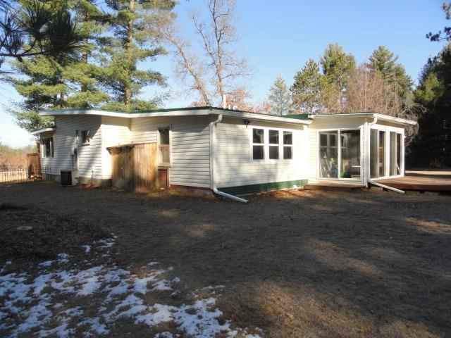 rear view of property with a sunroom and central AC