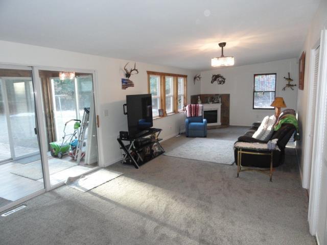 living area with light carpet and a fireplace