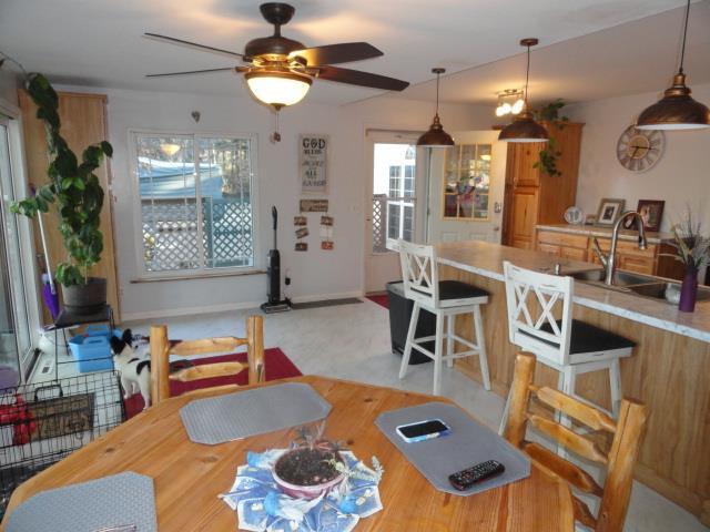 dining area featuring baseboards, ceiling fan, and wood finished floors