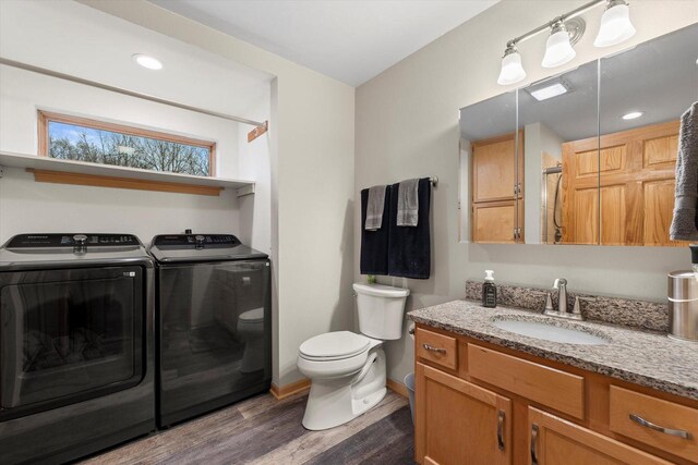 1646 N Friess Lake Dr, Hubertus, WI 53033 - bathroom featuring a shower, toilet, wood finished floors, vanity, and separate washer and dryer