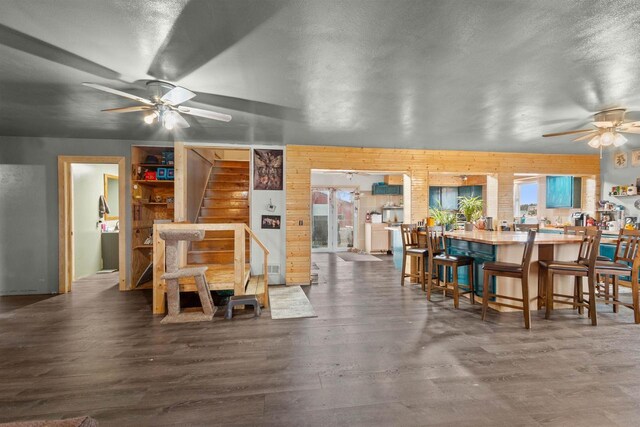 7760 State Highway 186, Arpin, WI 54410 - dining area featuring stairs, a ceiling fan, wooden walls, wood finished floors, and a textured ceiling