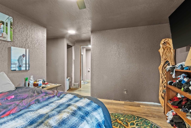 7760 State Highway 186, Arpin, WI 54410 - bedroom featuring wood finished floors, ceiling fan, a textured wall, and a textured ceiling