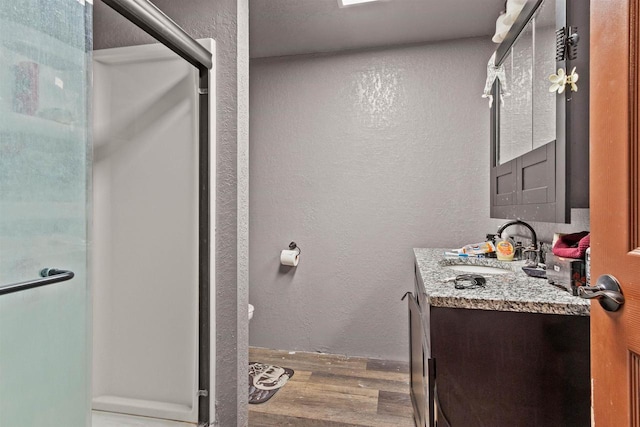 7760 State Highway 186, Arpin, WI 54410 - full bathroom with a textured wall, wood finished floors, a stall shower, and vanity