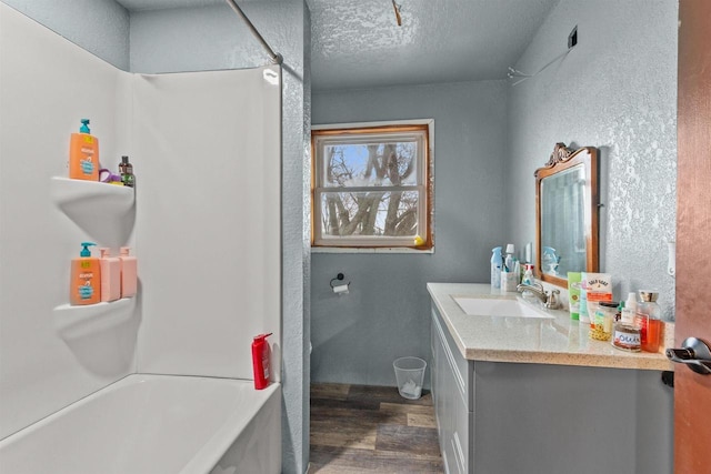 7760 State Highway 186, Arpin, WI 54410 - bathroom featuring shower / washtub combination, wood finished floors, vanity, and a textured ceiling