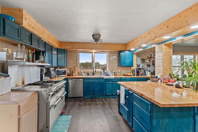 7760 State Highway 186, Arpin, WI 54410 - kitchen with dark wood-style floors, stainless steel appliances, wood counters, ceiling fan, and blue cabinetry