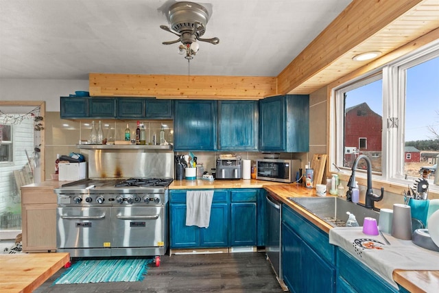 7760 State Highway 186, Arpin, WI 54410 - kitchen with a sink, butcher block countertops, blue cabinets, dark wood finished floors, and stainless steel appliances