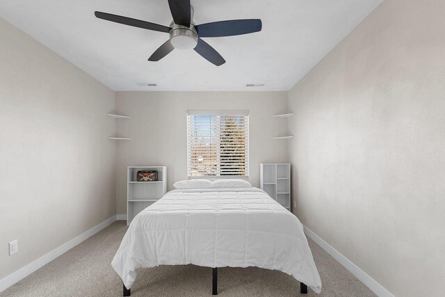 bedroom with baseboards, visible vents, and light colored carpet