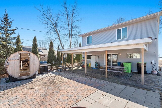 back of house with an outbuilding and a patio