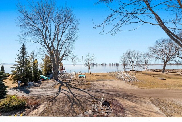 view of yard with playground community and a water view