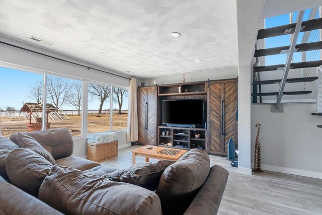 living area with light wood-type flooring, recessed lighting, baseboards, and visible vents