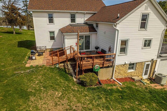 1943 State Road 11, South Wayne, WI 53587 - rear view of property featuring a lawn, a deck, roof with shingles, and central AC unit