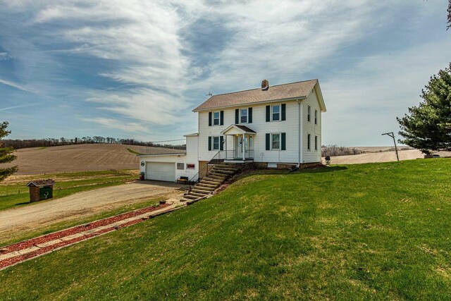 1943 State Road 11, South Wayne, WI 53587 - colonial inspired home with a garage, dirt driveway, and a front yard