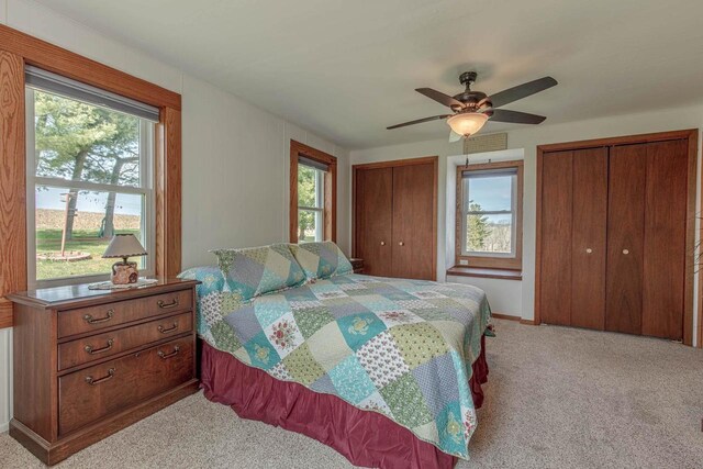 1943 State Road 11, South Wayne, WI 53587 - bedroom featuring baseboards, two closets, ceiling fan, and light carpet