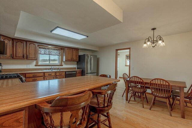 1943 State Road 11, South Wayne, WI 53587 - kitchen featuring a sink, a breakfast bar area, light wood-style flooring, a peninsula, and appliances with stainless steel finishes