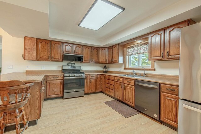 1943 State Road 11, South Wayne, WI 53587 - kitchen with brown cabinetry, appliances with stainless steel finishes, a sink, and light wood finished floors