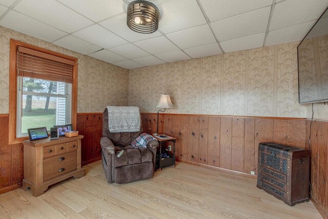 1943 State Road 11, South Wayne, WI 53587 - living area featuring a wainscoted wall, light wood-style floors, and a drop ceiling