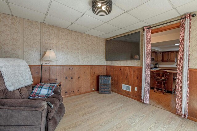 1943 State Road 11, South Wayne, WI 53587 - unfurnished room featuring light wood finished floors, wainscoting, visible vents, and a drop ceiling