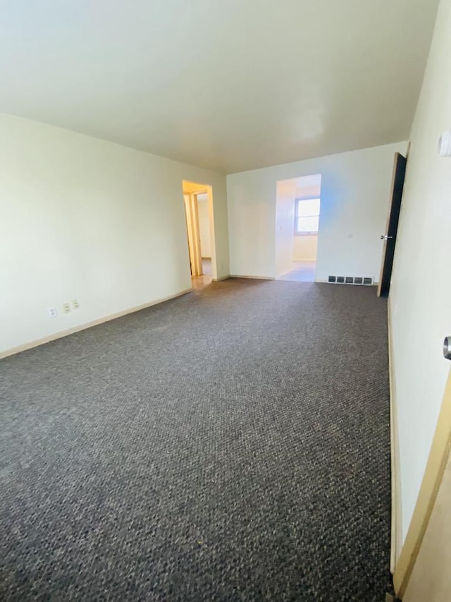 carpeted spare room with baseboards and visible vents