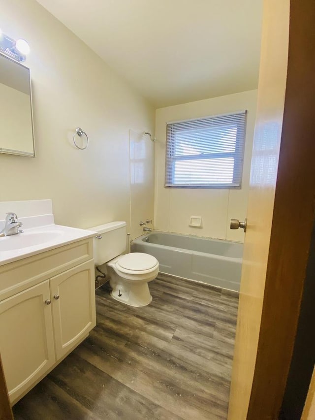 bathroom with toilet, vanity, shower / bathtub combination, and wood finished floors