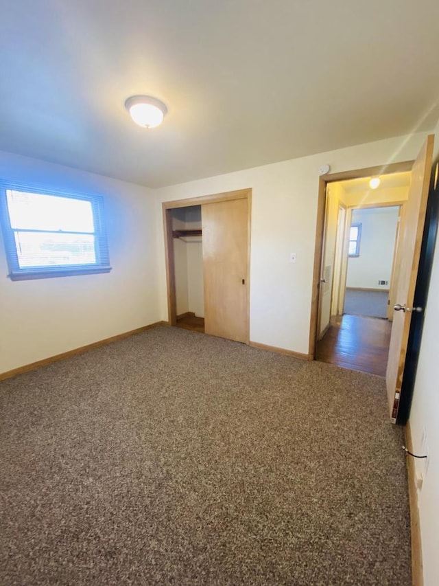 unfurnished bedroom featuring baseboards, a closet, and carpet floors
