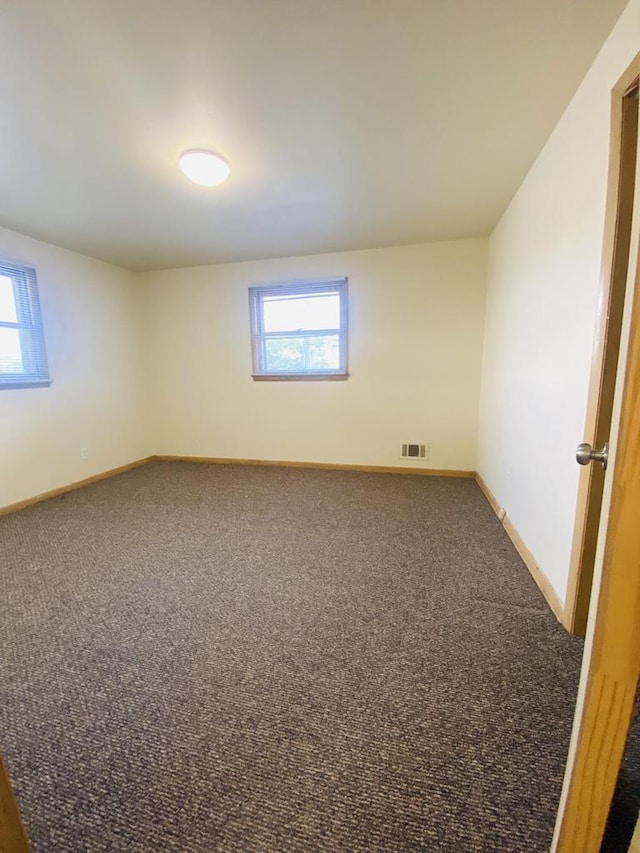unfurnished room featuring baseboards, a healthy amount of sunlight, and carpet