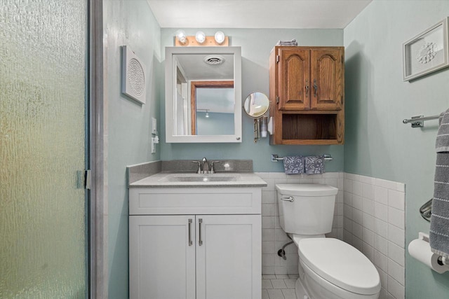 2925 Meadow Ln, Hartland, WI 53029 - bathroom featuring vanity, a wainscoted wall, toilet, visible vents, and tile walls