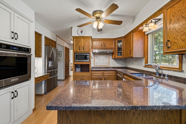 2925 Meadow Ln, Hartland, WI 53029 - kitchen with a sink, brown cabinetry, appliances with stainless steel finishes, and under cabinet range hood