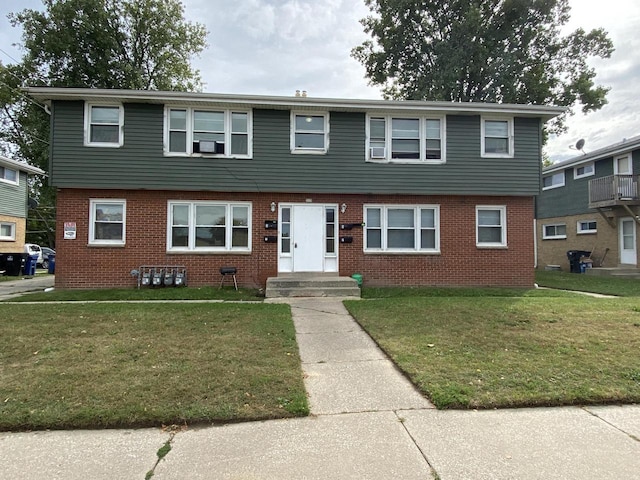 view of front of home featuring brick siding and a front lawn