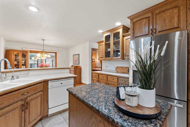 N8891 Gladstone Beach Rd, Fond Du Lac, WI 54937 - kitchen featuring freestanding refrigerator, white dishwasher, brown cabinetry, and glass insert cabinets